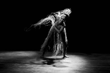 Çağdaş dansçı siyah arka plan ve saman aksesuarlarıyla tiyatroda dans ediyor. Salvador Bahia Brezilya.