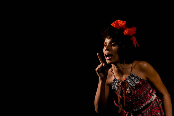 Actress on stage represents a dramatic character. She is standing. Scene in a theater in the city of Salvador, Brazil.