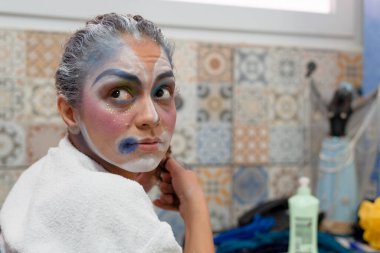 Aktris, tiyatro sahnesine girip karakterini oynamak için resim ve makyaj yapıyor. Sesi Tiyatrosu, Salvador, Bahia, Brezilya.