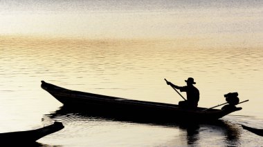 Cachoeira, Bahia, Brezilya - 29 Kasım 2014: Brezilya 'nın Bahia eyaletinde yer alan Paraguacu Nehri' ndeki teknesinde bir balıkçının günbatımında siluet.