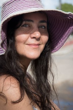 Pembe şapkalı ve kameraya bakan bir kadın. Acupe, Bahia, Brezilya.