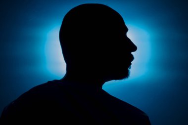 Mavi arka planda bir adamın kafasının yakın plan silueti. Salvador, Bahia, Brezilya.