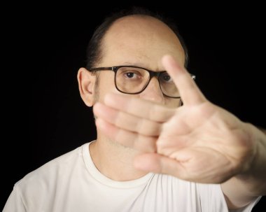 Siyah arka planda gözlük takan sakallı bir adamın portresi. Salvador, Bahia, Brezilya.