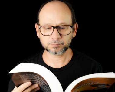 Siyah arka planda gözlük takan sakallı bir adamın portresi. Salvador, Bahia, Brezilya.