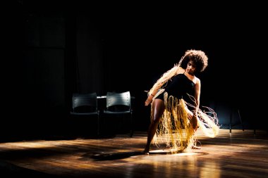 Çağdaş dansçı siyah arka plan ve saman aksesuarlarıyla tiyatroda dans ediyor. Salvador Bahia Brezilya.