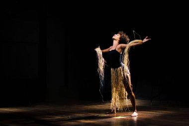 Çağdaş dansçı siyah arka plan ve saman aksesuarlarıyla tiyatroda dans ediyor. Salvador Bahia Brezilya.