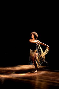 Çağdaş dansçı siyah arka plan ve saman aksesuarlarıyla tiyatroda dans ediyor. Salvador Bahia Brezilya.
