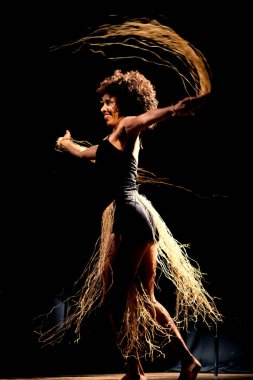 Çağdaş dansçı siyah arka plan ve saman aksesuarlarıyla tiyatroda dans ediyor. Salvador Bahia Brezilya.