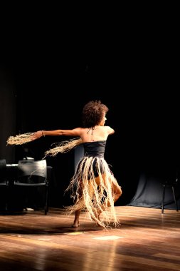 Çağdaş dansçı siyah arka plan ve saman aksesuarlarıyla tiyatroda dans ediyor. Salvador Bahia Brezilya.
