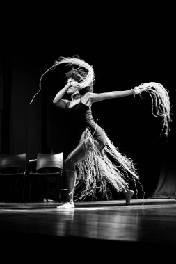 Çağdaş dansçı siyah arka plan ve saman aksesuarlarıyla tiyatroda dans ediyor. Salvador Bahia Brezilya.