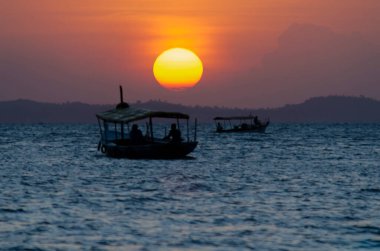 Brezilya, Bahia, Salvador 'da Ribeira sahilinden gün batımı görüldü. Denizde giden bir tekne.