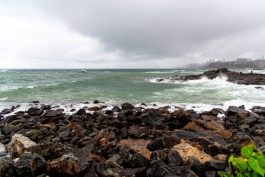 Dalgalı deniz sahildeki kayalara çarpıyor. Rio Vermelho, Salvador, Bahia, Brezilya.