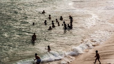 Salvador, Bahia, Brezilya - 22 Ağustos 2021: Brezilya 'nın Rio Vermelho semtindeki Paciencia plajında geniş bir grup insan. İnsanlar koronavirüs salgınının ortasında eğleniyorlar..