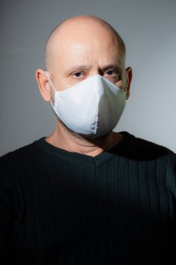 Siyah arka planda koruyucu maske takan bir adamın portresi. Salvador, Bahia, Brezilya