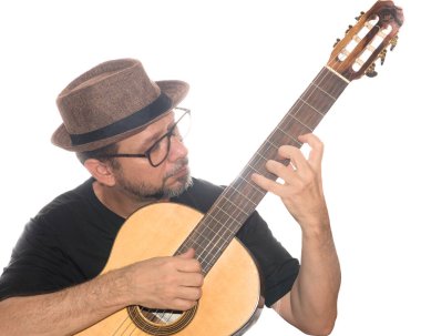 Beyaz arka planda gitar çalan gözlüklü ve şapkalı sakallı bir adamın portresi. Salvador, Bahia, Brezilya.
