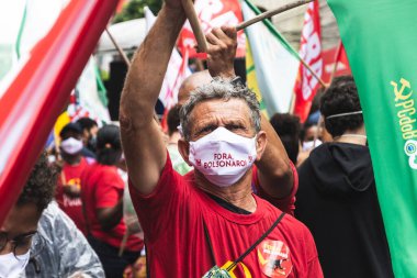 Salvador, Bahia, Brezilya - 24 Temmuz 2021: Salvador şehrinde halk Başkan Jair Bolsonaro hükümetini protesto ediyor. Sloganlı pankartlar, posterler, çıkartmalar ve maskeler kullanıyorlar..