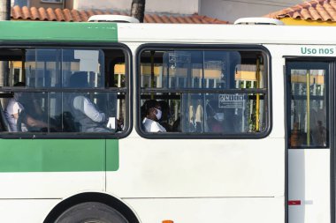 Salvador, Bahia, Brezilya - 30 Ekim 2020: Otobüsün içindeki insanlar koronavirüse karşı koruyucu maske takıyorlar. Salvador, Bahia, Brezilya.