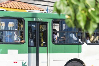 Salvador, Bahia, Brezilya - 30 Ekim 2020: Otobüsün içindeki insanlar koronavirüse karşı koruyucu maske takıyorlar. Salvador, Bahia, Brezilya.