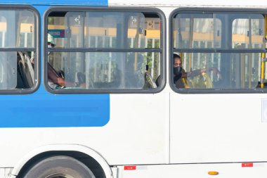 Salvador, Bahia, Brezilya - 30 Ekim 2020: Otobüsün içindeki insanlar koronavirüse karşı koruyucu maske takıyorlar. Salvador, Bahia, Brezilya.