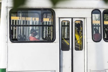 Salvador, Bahia, Brezilya - 30 Ekim 2020: Otobüsün içindeki insanlar koronavirüse karşı koruyucu maske takıyorlar. Salvador, Bahia, Brezilya.