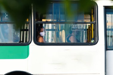 Salvador, Bahia, Brezilya - 30 Ekim 2020: Otobüsün içindeki insanlar koronavirüse karşı koruyucu maske takıyorlar. Salvador, Bahia, Brezilya.