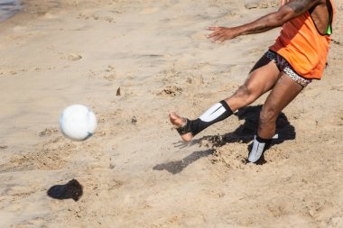 Salvador, Bahia, Brezilya - 15 Ağustos 2021: Salvador, Bahia, Brezilya 'daki Farol da Barra plajında elinde top olan bir adamın alt gövdesi.