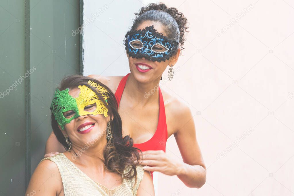 Portrait of two women wearing Venice Carnival mask. Salvador, Bahia, Brazil.