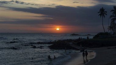 Salvador, Bahia, Brezilya 'da Ondina sahilinde dramatik turuncu gün batımı.