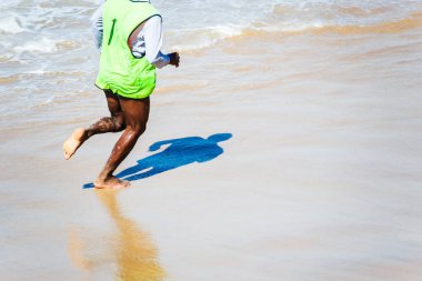 Salvador, Bahia, Brezilya - 15 Ağustos 2021: Bir insanın alt tarafı ve kumsaldaki gölgesi. Salvador Bahia Brezilya.