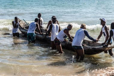 İnsanlar denizdeki kanolardaki balıkçıları izliyor. Iemanja 'nın onuruna Salvador, Bahia, Brezilya' daki Boca do Rio plajında kutlama.