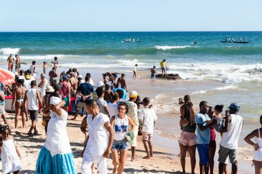 İnsanlar denizdeki kanolardaki balıkçıları izliyor. Iemanja 'nın onuruna Salvador, Bahia, Brezilya' daki Boca do Rio plajında kutlama.
