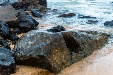 Dalgalı deniz sahildeki kayalara çarpıyor. Rio Vermelho, Salvador, Bahia, Brezilya.