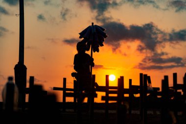 Salvador, Bahia, Brezilya - 01 Ekim 2021: Covid-19 tarafından öldürülenlerin anısına yere sabitlenmiş insan silueti ve haçlar. Salvador, Bahia, Brezilya 'da gün batımı.