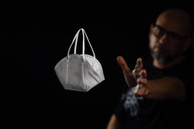 Siyah bir arka plan ve bir adama karşı koruyucu bir maskenin portresi. Salvador, Bahia, Brezilya.