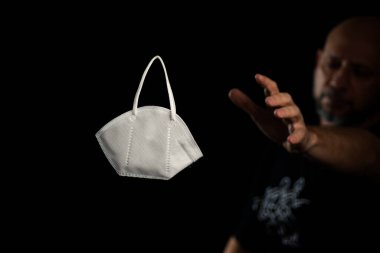 Siyah bir arka plan ve bir adama karşı koruyucu bir maskenin portresi. Salvador, Bahia, Brezilya.