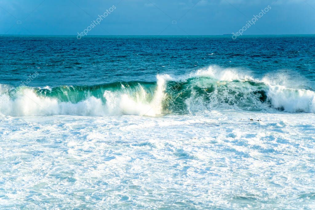 Medium waves crashing on the beach. Salvador city, Bahia state, Brazil.