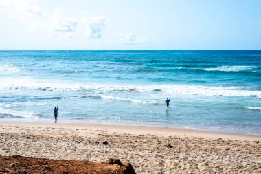 Salvador, Bahia, Brezilya - 10 Ekim 2021: Brezilya 'nın Bahia eyaletindeki Salvador' da Boca do Rio sahilinde iki balıkçı.