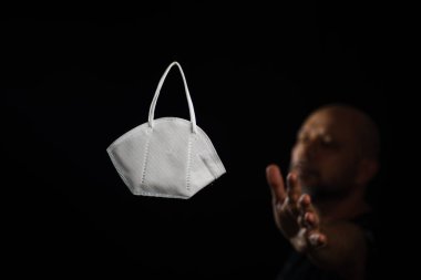 Siyah bir arka plan ve bir adama karşı koruyucu bir maskenin portresi. Salvador, Bahia, Brezilya.