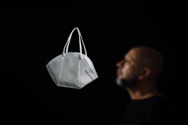 Siyah bir arka plan ve bir adama karşı koruyucu bir maskenin portresi. Salvador, Bahia, Brezilya.