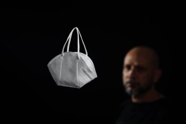 Siyah bir arka plan ve bir adama karşı koruyucu bir maskenin portresi. Salvador, Bahia, Brezilya.