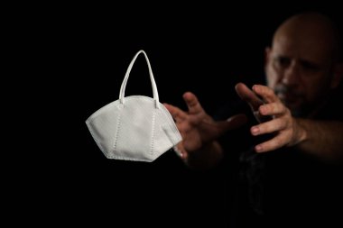 Siyah bir arka plan ve bir adama karşı koruyucu bir maskenin portresi. Salvador, Bahia, Brezilya.