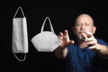 Covid-19 'a karşı iki koruyucu maskenin portresi ve siyah arka plana güvenen bir adam. Salvador, Bahia, Brezilya.