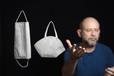 Covid-19 'a karşı iki koruyucu maskenin portresi ve siyah arka plana güvenen bir adam. Salvador, Bahia, Brezilya.