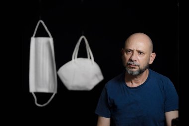 Covid-19 'a karşı iki koruyucu maskenin portresi ve siyah arka plana güvenen bir adam. Salvador, Bahia, Brezilya.