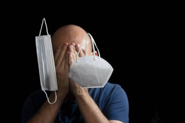 Covid-19 'a karşı iki koruyucu maskenin portresi ve siyah arka plana güvenen bir adam. Salvador, Bahia, Brezilya.