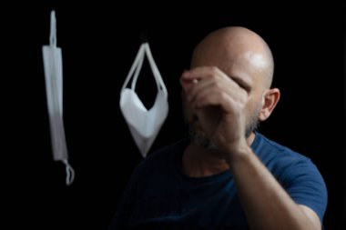 Covid-19 'a karşı iki koruyucu maskenin portresi ve siyah arka plana güvenen bir adam. Salvador, Bahia, Brezilya.