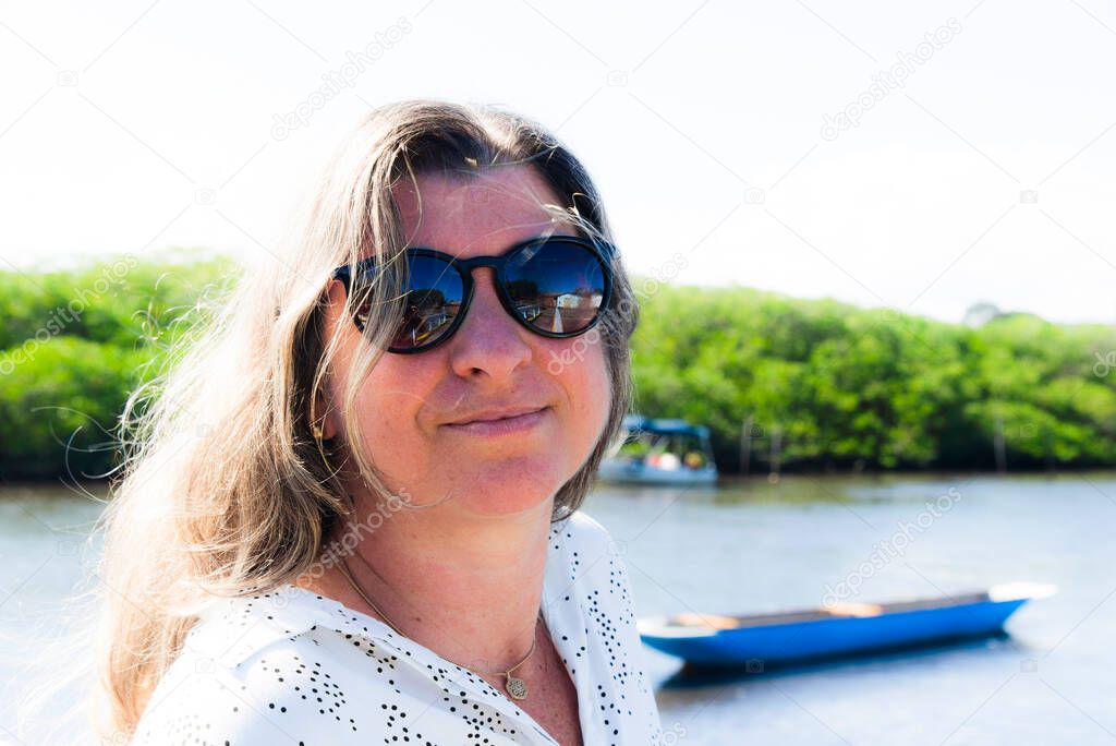 Portrait of a Caucasian woman looking at the camera against the street as a background. Aratuipe, Bahia, Brazil.