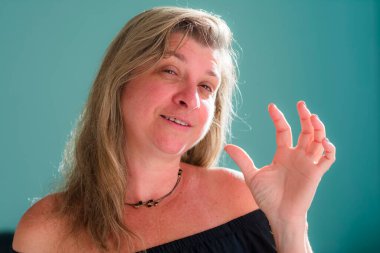 Açık yeşil arka planda kameraya bakan bir kadının portresi. Maragogipinho, Bahia, Brezilya.