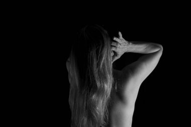 Sırtı kameraya dönük bir kadın stüdyoda siyah arka plana karşı. Salvador, Bahia, Brezilya.