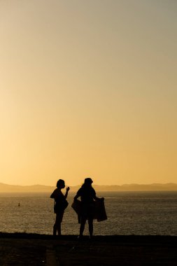 Gün batımına karşı bir grup insan silueti. Salvador, Bahia, Brezilya.